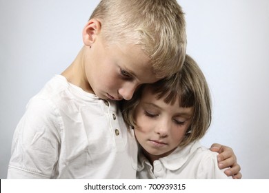 Portrait Of Grieving Young Children In An Embrace	