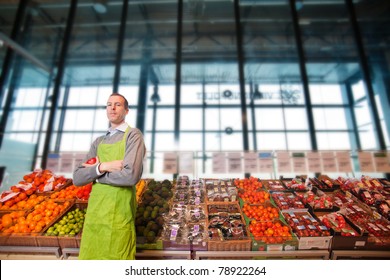 Portrait Of A Grocery Store Clkerk Or Owner In Front Of A Vegetable Counter