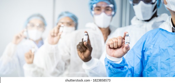 Portrait Group Of Active Multiethnic Doctor Or Scientist Team Development Wear PPE While Work In Laboratory Room, Research For Coronavirus Or COVID Vaccine During Pandemic. Drug Manufacturing Company.