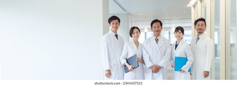 portrait of a group of asian doctors in white coats standing in a hospital corridor,
copy space on the left - Powered by Shutterstock