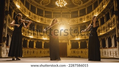 Portrait of a Group of Female Violinists Playing Violins While on the Stage of an Empty Classic Theatre. Musicians Rehearsing for a Big Classical Music Concert with Orchestra
