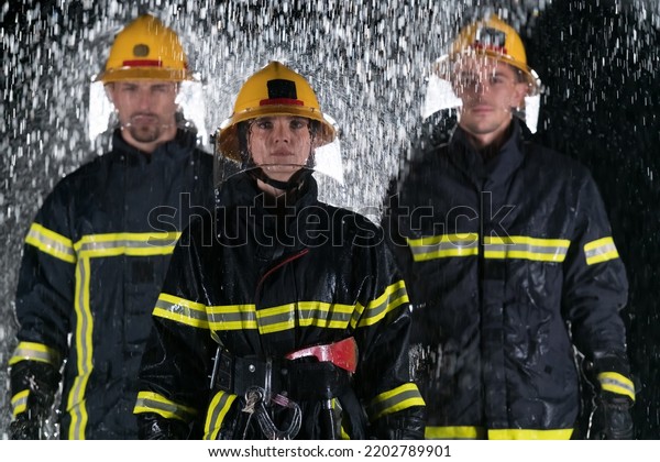 Portrait of a\
group of firefighters standing and walking brave and optimistic\
with a female as team\
leader.