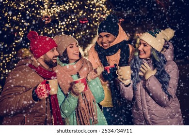 Portrait of group four buddies hold hot chocolate mug speak communicate enjoy festive atmosphere tree garland town center outdoors - Powered by Shutterstock