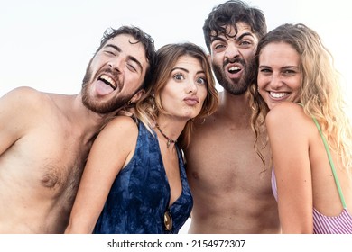 Portrait of a group of happy best friends in swimsuit making weird faces looking at the camera - young people having fun lifestyle concept