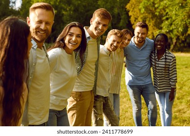 Portrait of a group of happy people friends standing in a row in the summer park hugging and smiling. Young students looking cheerful at camera outdoors. Friendship and togetherness concept. - Powered by Shutterstock