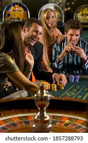 Portrait Of A Group Of Men And Women Gambling At The Roulette Table In The Casino