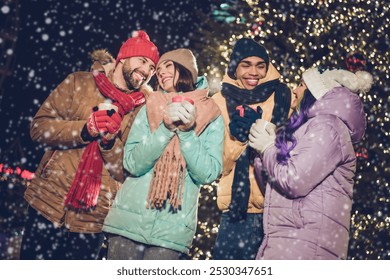 Portrait of group peaceful cheerful fellows hold hot chocolate coffee cup have good mood evening magic outside - Powered by Shutterstock