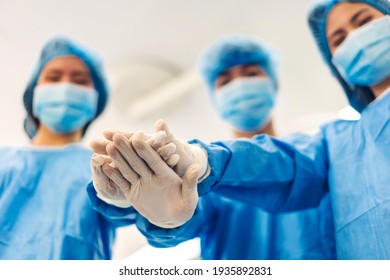 Portrait Of Group Successful Professional Anesthesiologist Doctor Medical Team And Assistant Stand Celebrating Success Putting And Joining Their Hands Teamwork Together In Modern Hospital