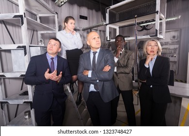 Portrait of group of thoughtful people in business suits at escape room