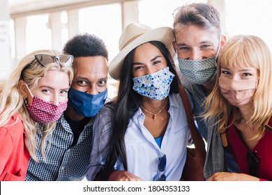 Portrait Group Of Young Happy Friends Wearing Face Mask During Covid Pandemic Smiling At The Camera. Multiracial People Taking A Selfie Outdoor Having Fun Together. New Normal Lifestyle Concept.