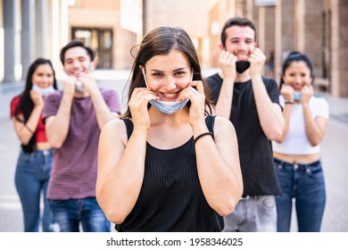 Portrait of a group of young millennial friends lower the mask and smile -Tools need to wearing avoid the infection from Coronavirus, Covid-19 - People having fun together - Concept of freedom - Shutterstock ID 1958346025