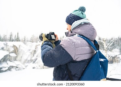 Portrait, The guy photographs the winter landscape in a mountain park, a panoramic scenic view