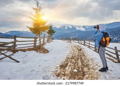 Portrait, The guy photographs the winter landscape in a mountain park, a panoramic scenic view