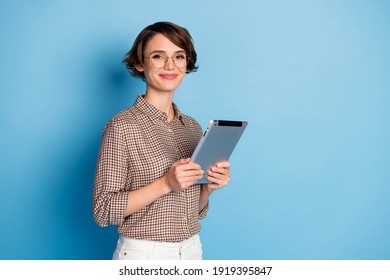 Portrait of half turned nice person smile holding tablet wear checkered outfit isolated on blue color background