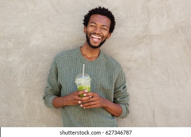 Portrait of handsome african american man with green smoothie - Powered by Shutterstock