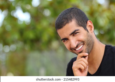 Portrait Of A Handsome Arab Man Face Outdoors In A Park With A Green Background