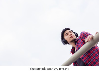 Portrait Handsome Asian Guy Attractive Handsome Young Man Looking Away With Sky Background Copy Space Cool Guy Wear Headphones And Red Shirt Charming Men Get Determined And Confident He Look Smart