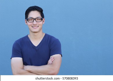 Portrait of a handsome Asian man with glasses crossing his arms