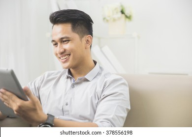Portrait Of Handsome Asian Man Using Tablet Pc At Home