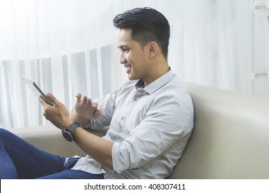 Portrait Of Handsome Asian Man Using Tablet Pc At Home