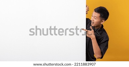 Portrait of handsome asian man wearing casual outfit isolated on orange background behind wall showing sales promotion. white wall copyspace for advertisement