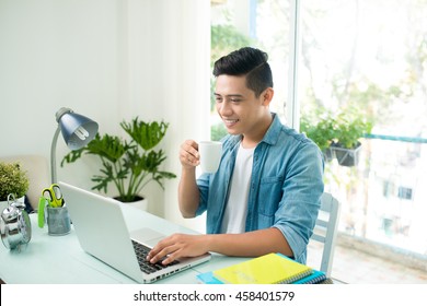 Portrait Of Handsome Asian Young Business Man Working On Laptop Computer At Office Desk