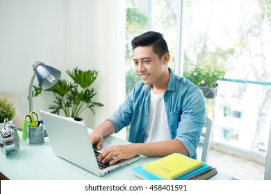 Portrait Of Handsome Asian Young Business Man Working On Laptop Computer At Office Desk