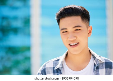 Portrait of handsome Asian young man smiling at camera