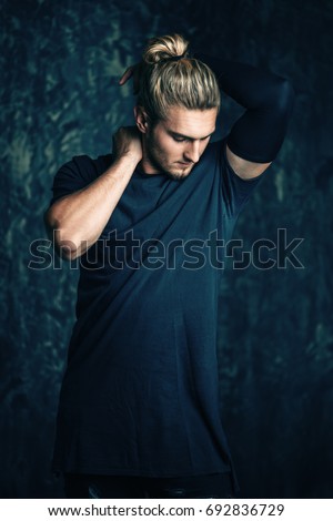 Portrait of a handsome athletic man posing over grunge background. Urban style.