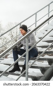 Portrait Of Handsome Athletic Man Sitting On Stairs Before His Winter Workout Outside