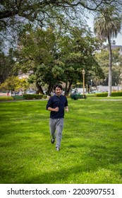 Portrait Of Handsome Attractive Mature Bearded Athletic Latin Man Guy 40s In Casual Blue T-shirt Running At A Park