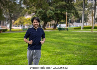 Portrait Of Handsome Attractive Mature Bearded Athletic Latin Man Guy 40s In Casual Blue T-shirt Running At A Park