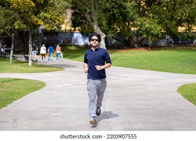 Portrait Of Handsome Attractive Mature Bearded Athletic Latin Man Guy 40s In Casual Blue T-shirt Running At A Park