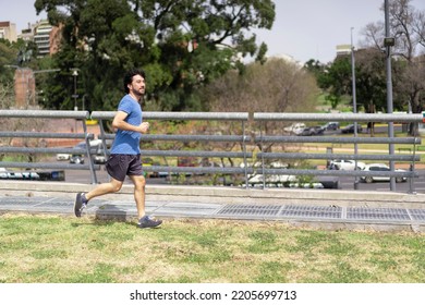 Portrait Of Handsome Attractive Mature Bearded Athletic Latin Man Guy 40s In Casual Blue T-shirt Running At A Park. Speed Concept.