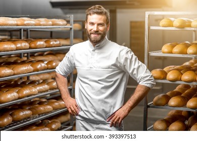 Portrait of handsome baker at the bakery with breads and oven on the background - Shutterstock ID 393397513