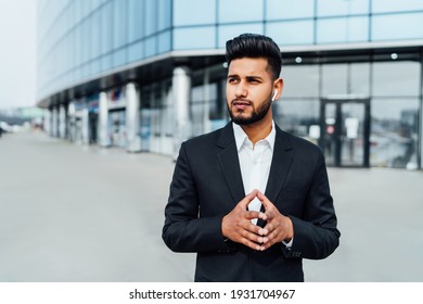 Portrait of a handsome bearded Indian businessman, boss, behind him a large building. Place for an inscription, modern Indian man.