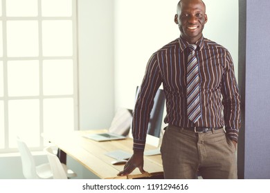 Portrait of an handsome black businessman standing in office - Shutterstock ID 1191294616