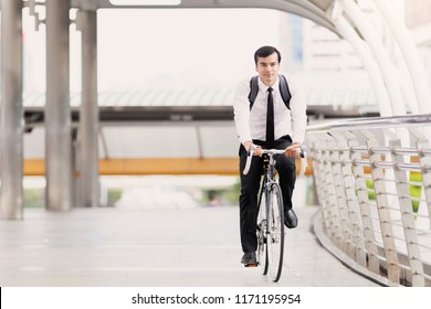 Portrait handsome businessman caucasian wearing  white shirt with a necktie uniform in company employee using riding a bicycle work in the city, Concept healthy and ecology bike go to a work