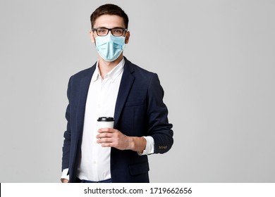 Portrait Of A Handsome Businessman In Eyeglasses And Face Mask With A Cup Of Coffee.