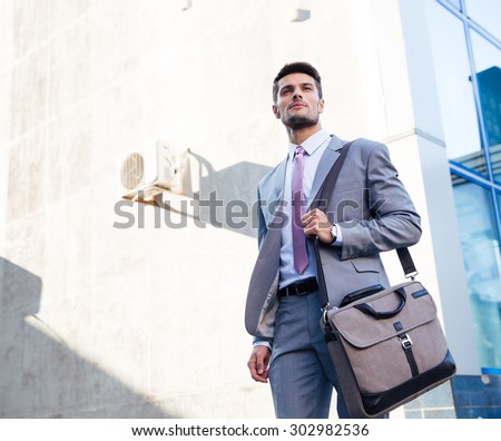 Portrait of a handsome businessman standing outdoors near office building