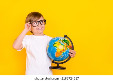 Portrait of handsome cheerful creative pre-teen boy holding globe thinking copy space isolated over bright yellow color background - Powered by Shutterstock