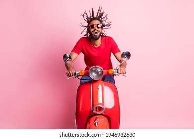 Portrait of handsome cheery dreamy guy riding moped having fun wind blowing spending summer isolated over pink pastel color background - Powered by Shutterstock