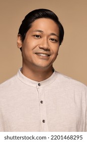 Portrait Of Handsome Chinese Man In His 30s Smiling And Posing Confidently On Neutral Background