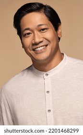 Portrait Of Handsome Chinese Man In His 30s Smiling And Posing Confidently On Neutral Background