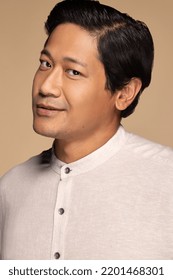 Portrait Of Handsome Chinese Man In His 30s Smiling And Posing Confidently On Neutral Background