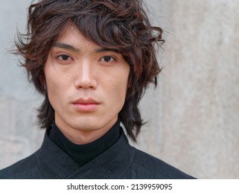 Portrait Of Handsome Chinese Young Man In Black Looking At Camera With Gray Wall Background, Front View Of Confident Young Man, Close Up View Head Shot.