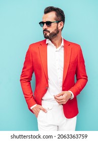 Portrait of handsome confident stylish hipster lambersexual model.Sexy modern man dressed in elegant red suit. Fashion male posing in studio near blue wall in sunglasses - Shutterstock ID 2063363759