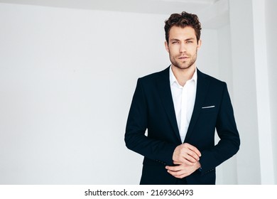 Portrait Of Handsome Confident Stylish Hipster Lambersexual Model. Sexy Modern Man Dressed In Black Elegant Suit. Fashion Male Posing In Studio On White Background