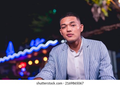 Portrait Of A Handsome And Dapper Young Man Hanging Out At An Outdoor Bar. Nightlife Scene At A Popular Spot.