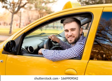 Portrait of handsome driver in taxi car